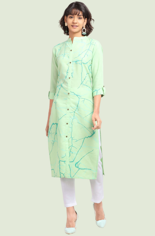 Woman wearing a light green kurta with white pants on a light green background